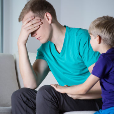 Depressed father sitting on couch