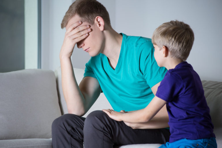 Depressed father sitting on couch